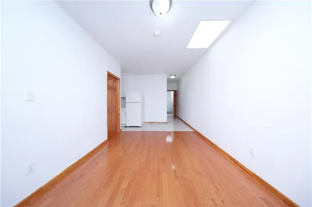 a view of a room with wooden floor and white walls
