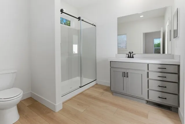 a bathroom with a double vanity sink toilet and shower