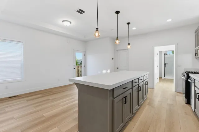 a kitchen with a stove and a wooden floor