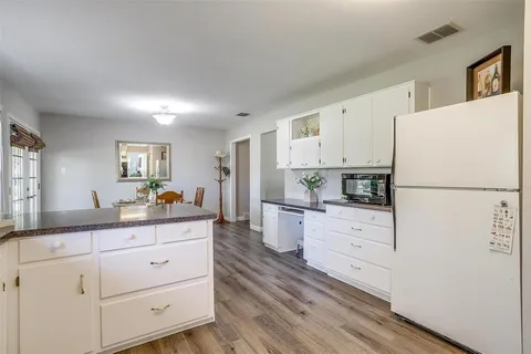 a kitchen with granite countertop white cabinets and white appliances
