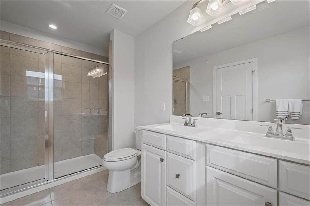 232 Cranesbill Drive Mars, PA 16046 - Photo 20 of 25 a bathroom with a toilet a sink a glass door a shower a mirror and vanity