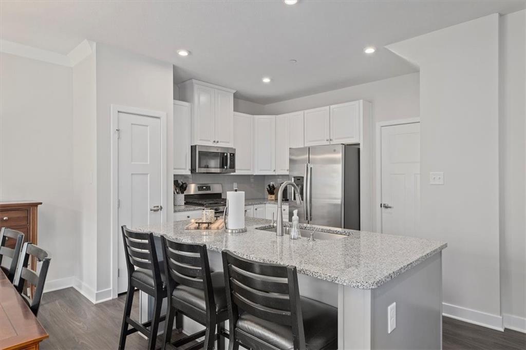 232 Cranesbill Drive Mars, PA 16046 - Photo 8 of 25 a kitchen with kitchen island granite countertop a table chairs microwave and cabinets