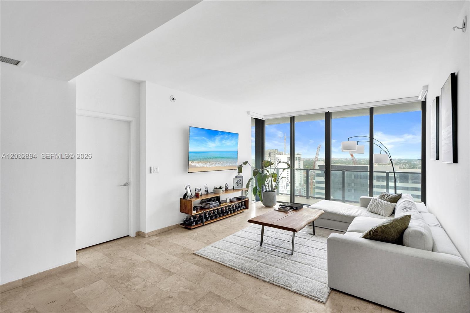 88 Southwest 7th Street, Unit 2210 Miami, FL 33130 - Photo 7 of 24 Open living room with floor-to-ceiling glass, city views and balcony access.