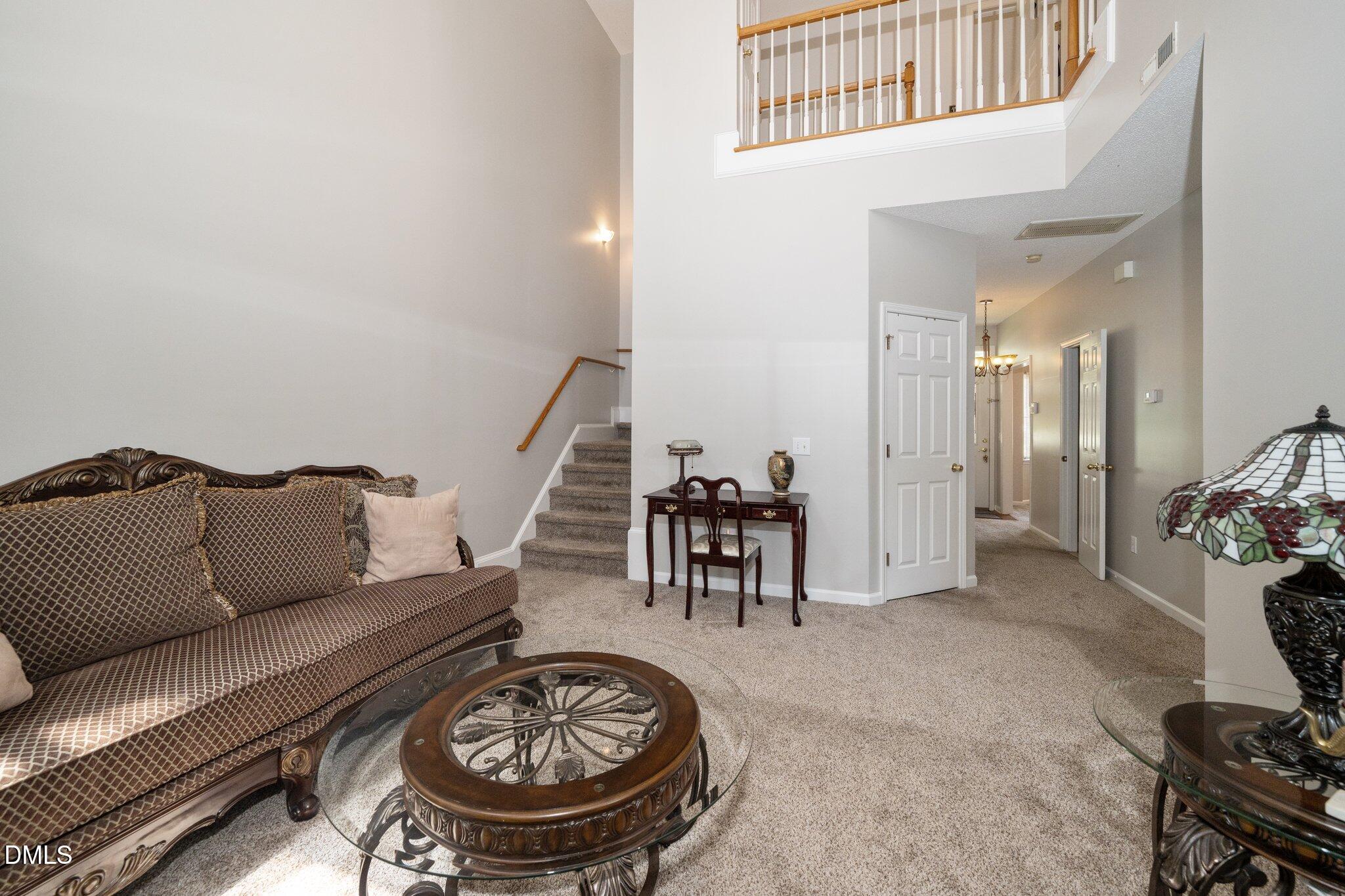 6008 River Lake Circle Raleigh, NC 27604 - Photo 8 of 16 a living room with furniture a rug and a chandelier