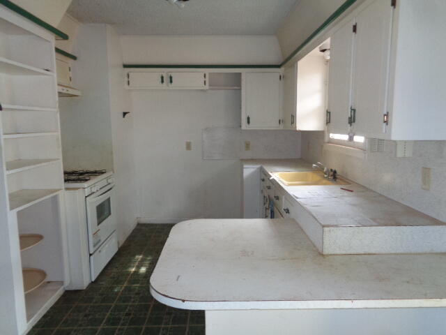 1329 49th Street Lubbock, TX 79412 - Photo 4 of 13 a bathroom with a sink a toilet and a mirror