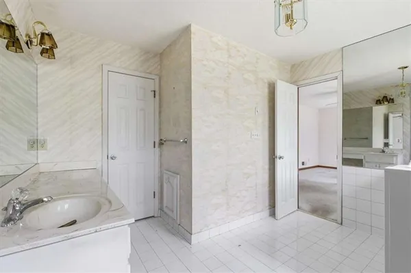 a bathroom with a tub a sink and mirrors