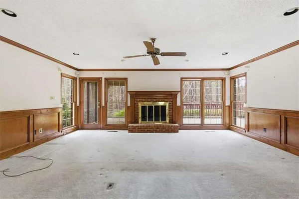 a view of an empty room with a fireplace and a window