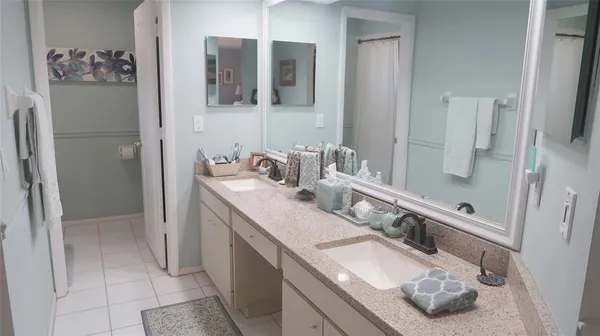 a bathroom with double vanity and a mirror