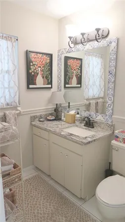 a bathroom with a granite countertop toilet sink and mirror