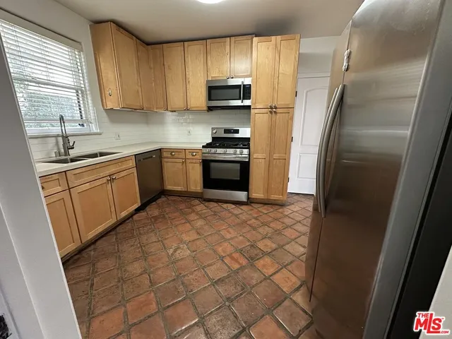 a kitchen with granite countertop a refrigerator and a sink