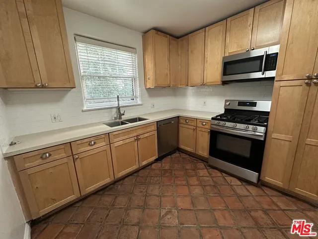 a kitchen with a sink a stove and cabinets