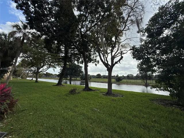 a view of yard with green space and trees