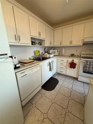 a kitchen with a sink a stove and cabinets