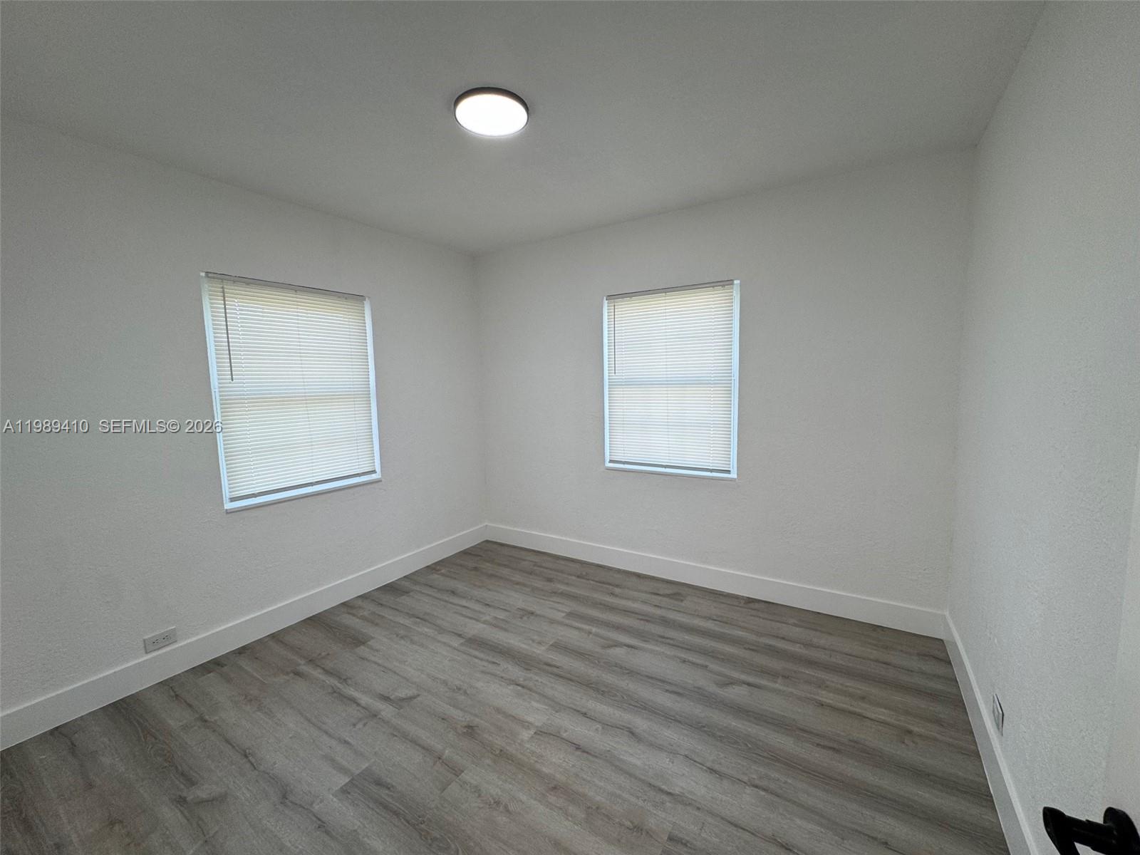 2450 Northwest 157th St Road Miami Gardens, FL 33054 - Photo 15 of 24 an empty room with wooden floor and windows