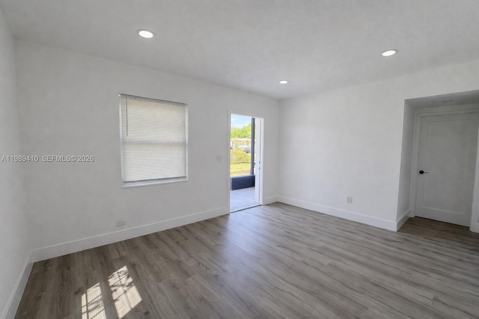 2450 Northwest 157th St Road Miami Gardens, FL 33054 - Photo 4 of 24 an empty room with wooden floor and windows