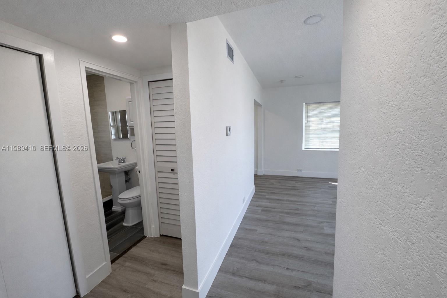 2450 Northwest 157th St Road Miami Gardens, FL 33054 - Photo 8 of 24 a view of a hallway with wooden floor and closet