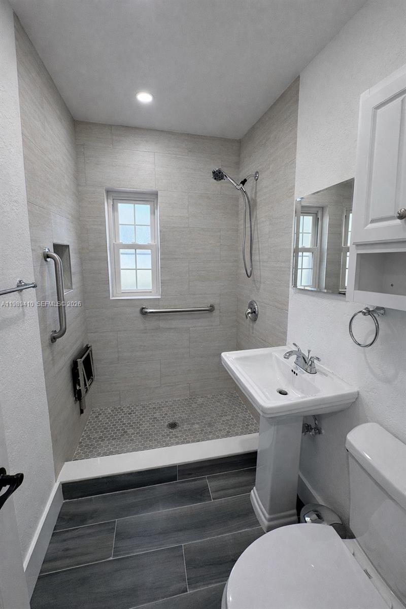 2450 Northwest 157th St Road Miami Gardens, FL 33054 - Photo 9 of 24 a bathroom with a sink toilet and mirror