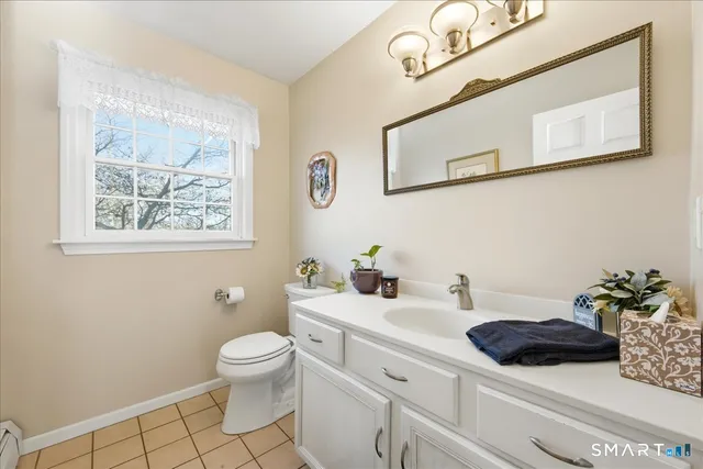 a bathroom with a toilet a sink and mirror
