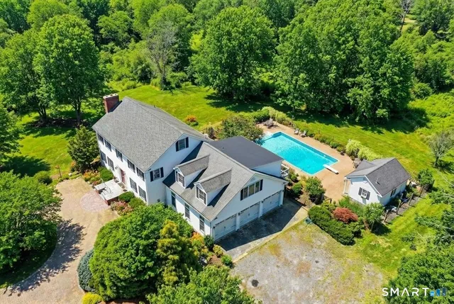 an aerial view of a house with swimming pool and garden