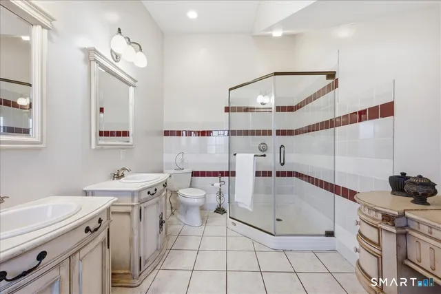 a bathroom with a sink a toilet a mirror and shower