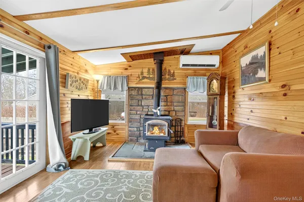 a living room with furniture a flat screen tv and a floor to ceiling window