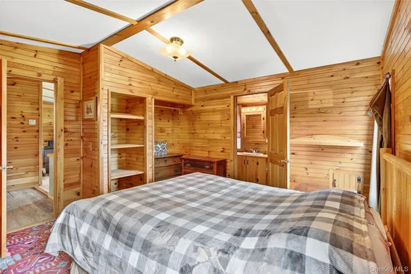 a bedroom with a bed and a flat tv screen