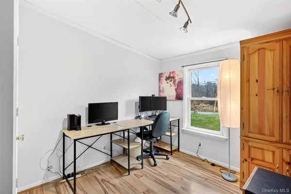 a view of a workspace with furniture and a window