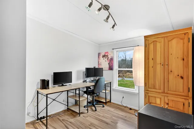 a view of a workspace with furniture and a window