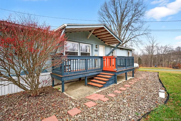 a view of backyard with deck and wooden fence