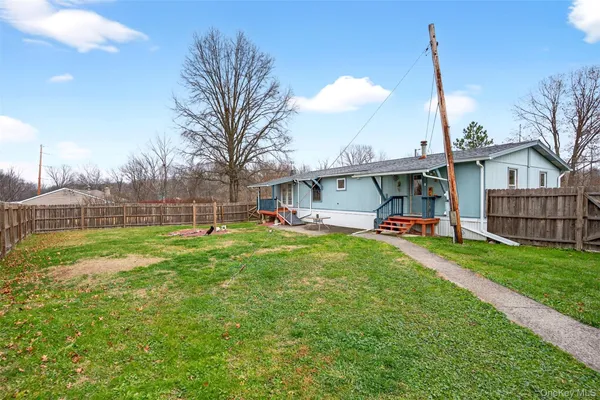 a view of a house with backyard and a tree
