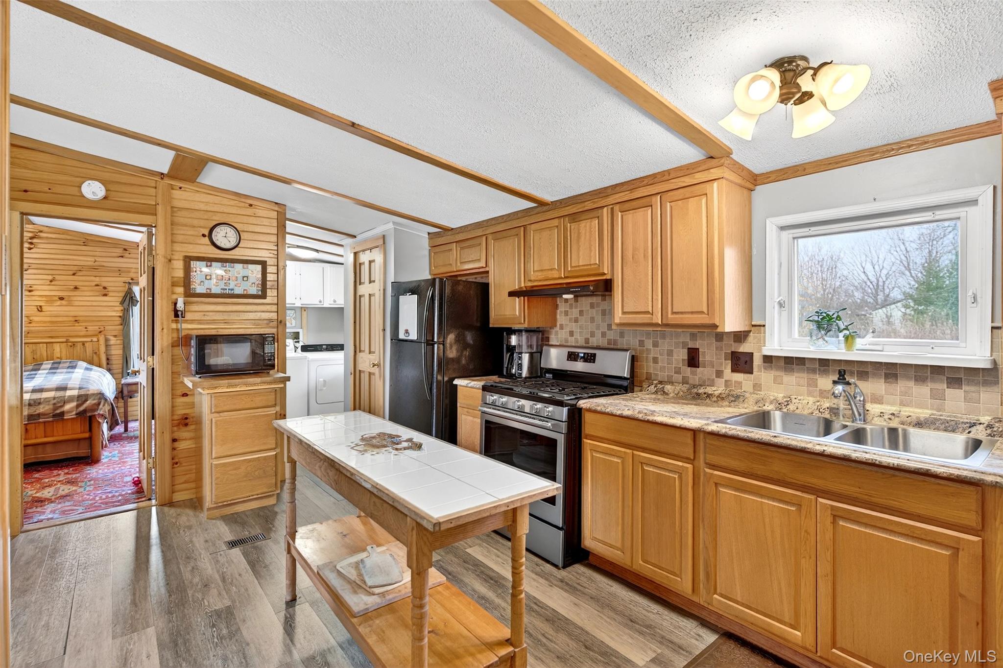 448 Sand Hill Road Gardiner, NY 12525 - Photo 7 of 29 a kitchen with a refrigerator a stove a sink dishwasher a dining table and chairs with wooden floor