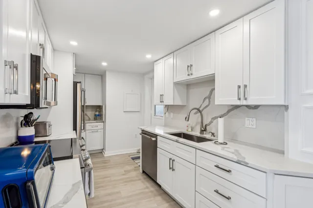 a kitchen with granite countertop a sink stainless steel appliances and cabinets