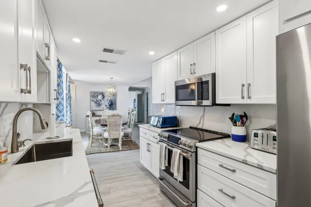 a kitchen with stainless steel appliances a stove sink and cabinets