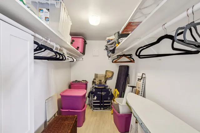 a view of walk in closet with clothes and shoes