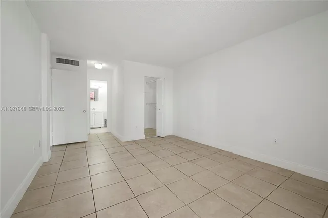 a view of an empty room and closet area