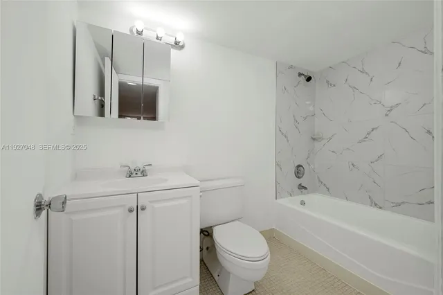 a bathroom with a toilet a sink a mirror a bathtub and vanity