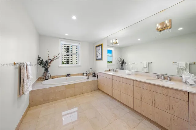 a large bathroom with a sink mirror and a bath tub