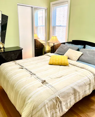 a bedroom with a bed and wooden floor