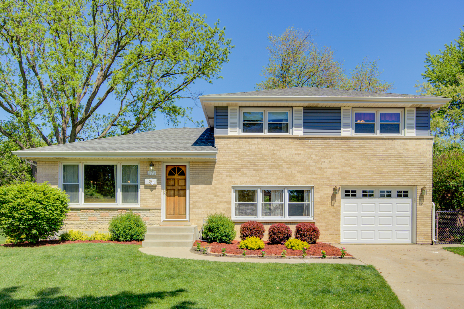 272 Scott Street Wheeling, IL 60090 - Photo 1 of 28 a front view of a house with a garden and yard