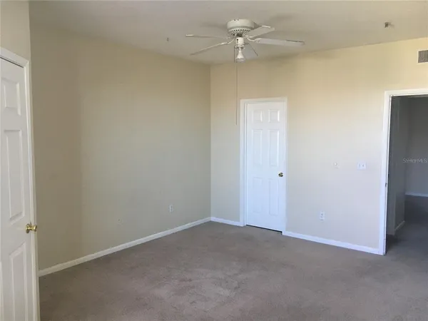 an empty room with a ceiling fan and a window
