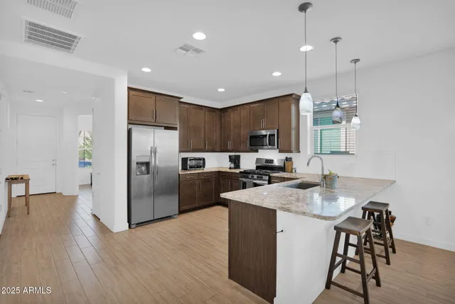 a kitchen with refrigerator a sink and chairs