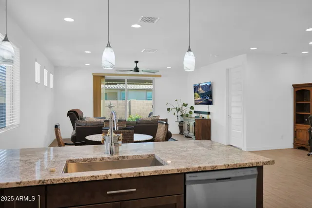 a kitchen with granite countertop living room and white cabinets