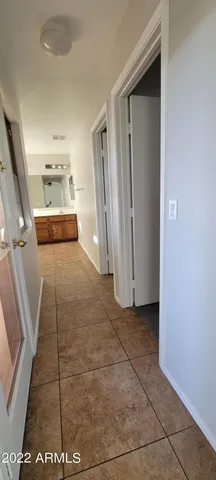 a view of a refrigerator in kitchen and an empty room