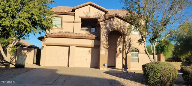 a front view of a house with a tree