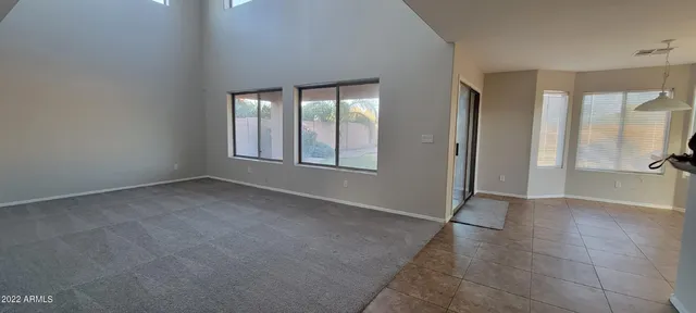 a view of an empty room with glass door and wooden floor