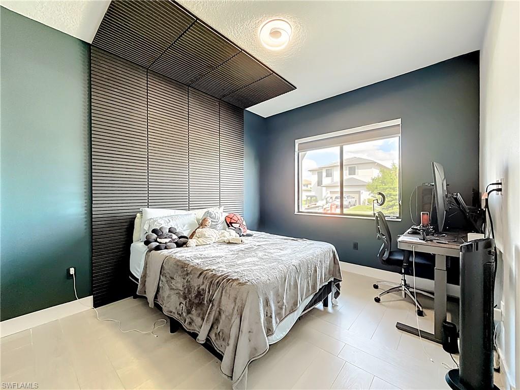 5277 Lamone Ln Avenue Immokalee, FL 34142 - Photo 15 of 27 a bedroom with a bed and a computer on the desk