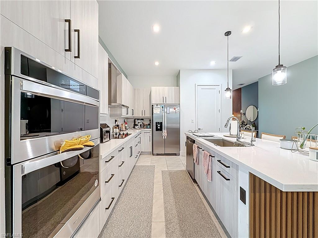 5277 Lamone Ln Avenue Immokalee, FL 34142 - Photo 6 of 27 a large white kitchen with stainless steel appliances lots of counter space and wooden floor