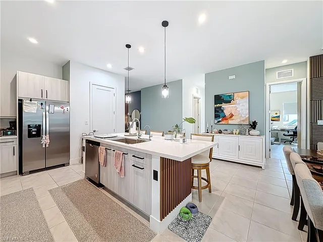 a living room with furniture kitchen view and a large window