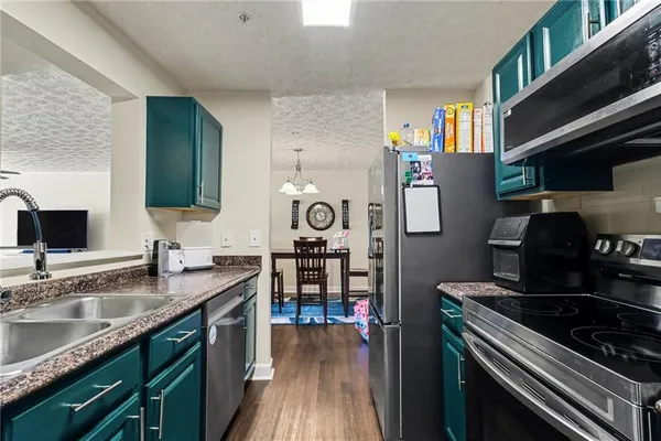 a kitchen with granite countertop a sink stove and cabinets