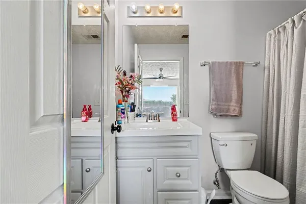 a bathroom with a sink vanity mirror and toilet